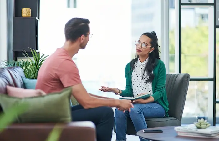 A female career counselor engaging in a supportive one-on-one interview with a male candidate, demonstrating the personalized job placement and coaching services available for adults with autism in San Diego.