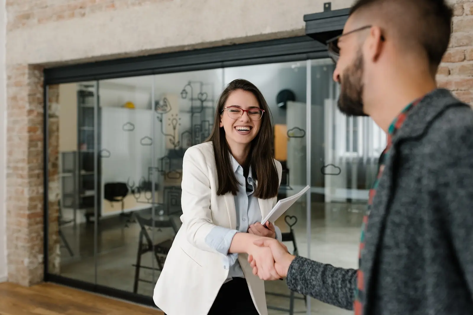 Young woman shaking the hand of a young man starting an autism tech career