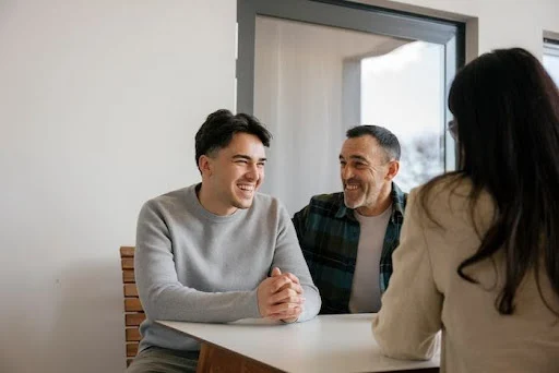 A young adult with his father getting counseling on resources for autistic adults