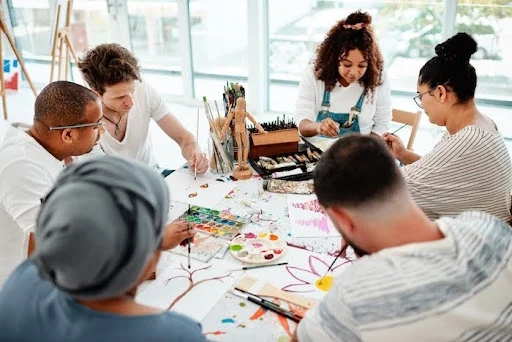 Young adults in a creative arts workshop for autistic adults